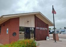 Brick post office in Ovid Colorado with the American flag posted outside